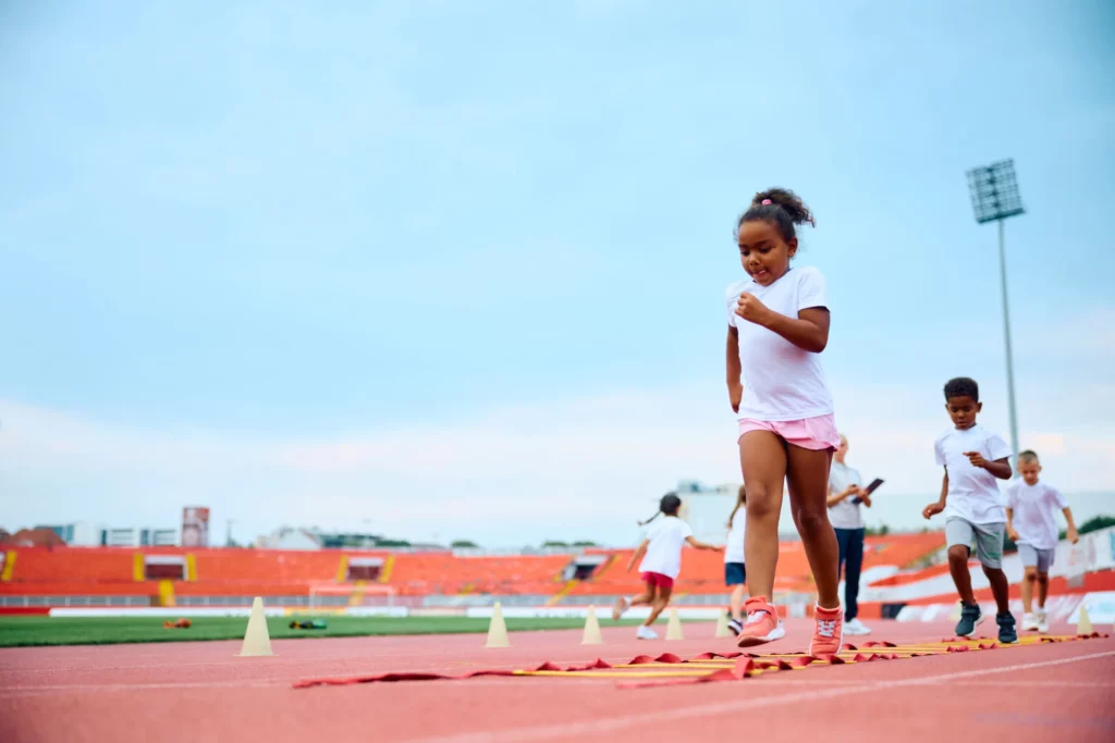 Enfants pratiquant le sport en stade pour illustrer le partenariat solidaire entre l'association LC2D et le Groupe Orion pour l'égalité des chances.