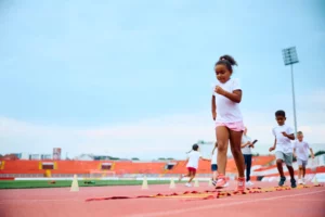 Enfants pratiquant le sport en stade pour illustrer le partenariat solidaire entre l'association LC2D et le Groupe Orion pour l'égalité des chances.